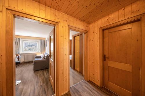 a living room with wooden walls and a door at Appartamento Primavera 3 in Moena