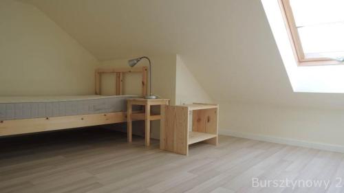 Schlafzimmer mit einem Bett, einem Schreibtisch und einem Fenster in der Unterkunft Bursztynowy 2 in Karwia