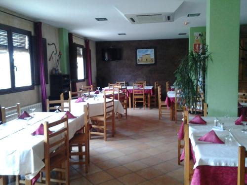 a dining room with tables and chairs with white tablecloths at Hotel CTR San Baudelio in Casillas de Berlanga