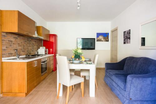 a small kitchen with a table and a blue couch at Villa Cinzia-150 mt from the beach in Mondello