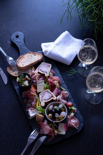 a plate of food with meat and bread and glasses of wine at Hotel L'Europe in Colmar