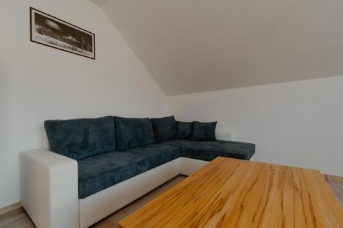 a living room with a couch and a wooden table at Apartmány Zara in Nová Lesná