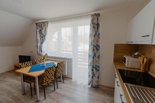 a kitchen with a table and chairs and a microwave at Apartmány Zara in Nová Lesná