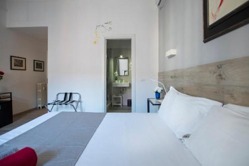 ローマにあるRaffaela's Suite & Rooms Vatican Guest Houseのベッドルーム(白い大型ベッド、白い枕付)