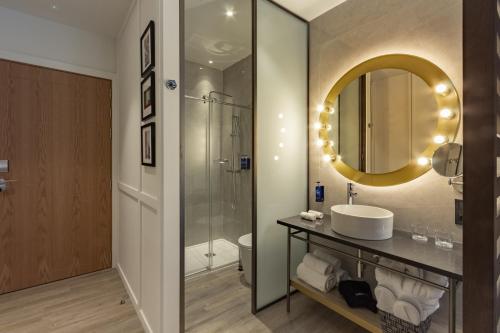 uma casa de banho com um lavatório e um espelho em Pestana CR7 Gran Vía Madrid em Madrid