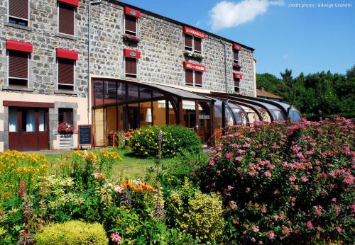 Un bâtiment avec un bouquet de fleurs devant lui dans l'établissement Les Hirondelles, à Orcines