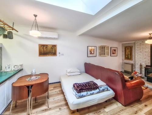 a living room with a couch and a table at Bidwell Cottage in Daylesford