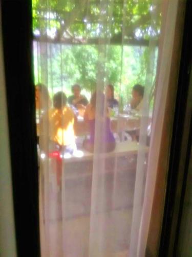 a group of people sitting at a table through a window at Il Casale di Aquarubra in Celleno
