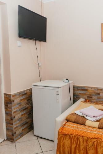 a room with a dryer and a television on a wall at Vila Verona Sobe in Palić