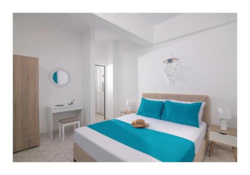 ein Schlafzimmer mit einem großen Bett mit blauen Kissen in der Unterkunft Kastri Mare Sea View Residences by Estia in Keratókambos
