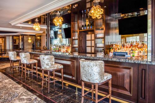 a bar with bar stools in a room at Chateau Vaudreuil in Vaudreuil-Dorion