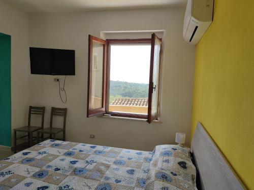 a bedroom with a bed and a window at Sa Dommu 'e su coro in Triei
