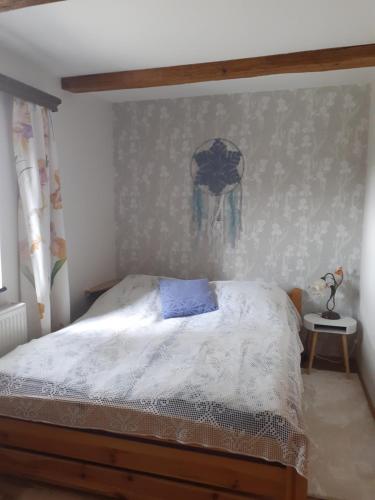 a bedroom with a bed with a blue pillow on it at Agroturystyka Łysa Góra in Jelenia Góra