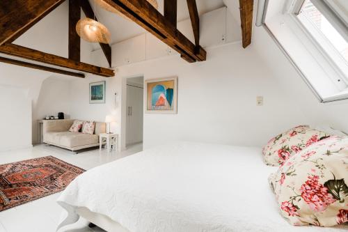 een witte slaapkamer met een groot bed en een bank bij The Blue House in Brugge