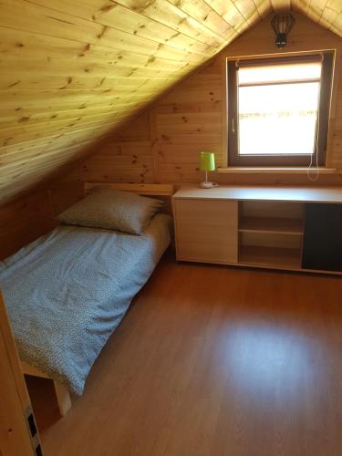 a bedroom with a bed and a desk and a window at Gucio in Zwierzyniec