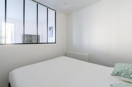 a white bedroom with a bed and a window at Welcome perche ! Appartements 3 étoiles à NOGENT le Rotrou in Nogent-le-Rotrou