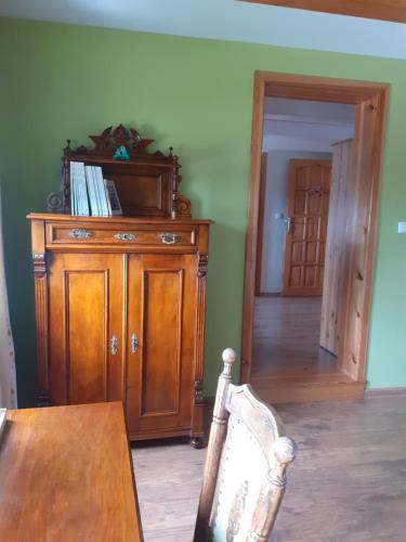a dining room with a table and a wooden cabinet at Agroturystyka Łysa Góra in Jelenia Góra