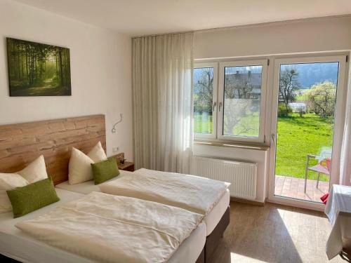 ein Schlafzimmer mit einem Bett und einem großen Fenster in der Unterkunft Römercastell Wirtshaus & Hotel in Böhming