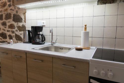 uma cozinha com um lavatório e comodidades para preparar café em Sokaki House em Hidra