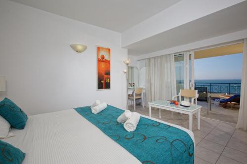 a bedroom with a bed and a view of the ocean at Rethymno Mare Royal & Water Park in Skaleta