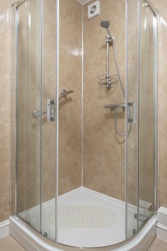 a shower with a glass enclosure in a bathroom at Stonehaven ground floor home with a spectacular harbour view. in Stonehaven