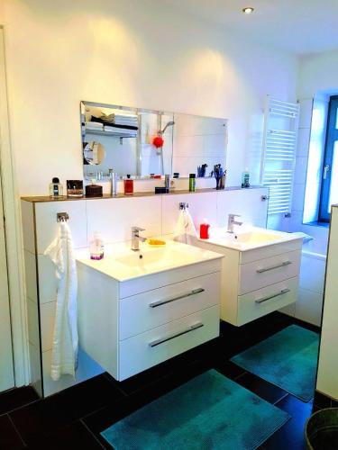 a white bathroom with two sinks and a mirror at Villa Appartements Syke in Syke