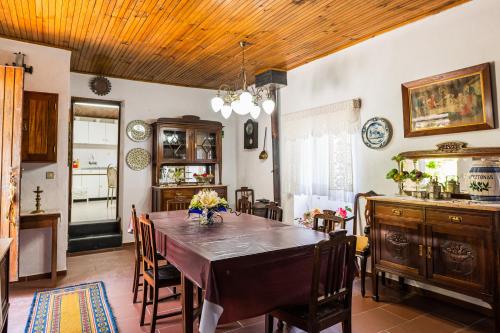 uma cozinha e sala de jantar com mesa e cadeiras em Quinta do Pereiro de Cima em Castelo de Paiva