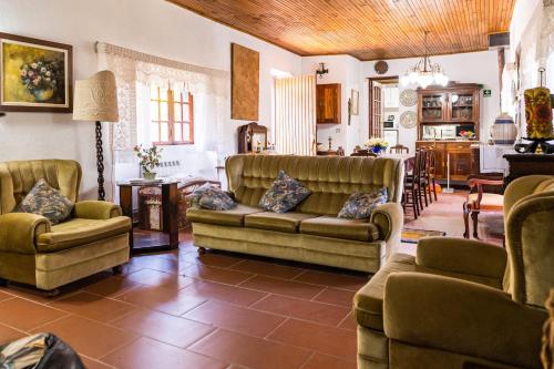 uma sala de estar com sofás e uma sala de jantar em Quinta do Pereiro de Cima em Castelo de Paiva