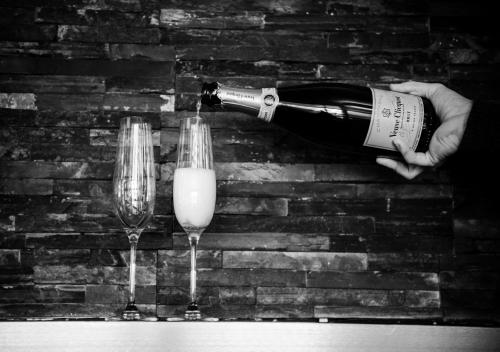 a person holding a bottle of wine next to two glasses at Nevis Bank Inn in Fort William