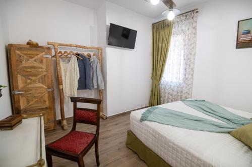a bedroom with a bed and a chair and a window at Stoa Luxury House with Unique Jacuzzi Room in Mourné