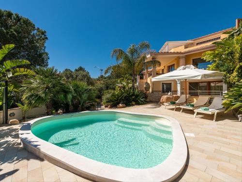 a swimming pool in a yard with a house at B&B Giglio di Chia in Domus de Maria