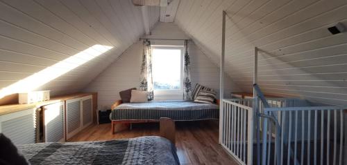 a attic room with a bed and a window at Wolnostojący dom na dużym prywatnym terenie -pet friendly- in Lubin