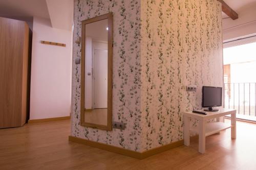 a room with a mirror and a tv on a wall at MORELLA CENTRO Apartamento-Loft in Morella