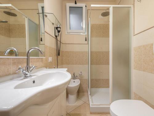 a bathroom with a sink and a toilet and a shower at B&B Giglio di Chia in Domus de Maria