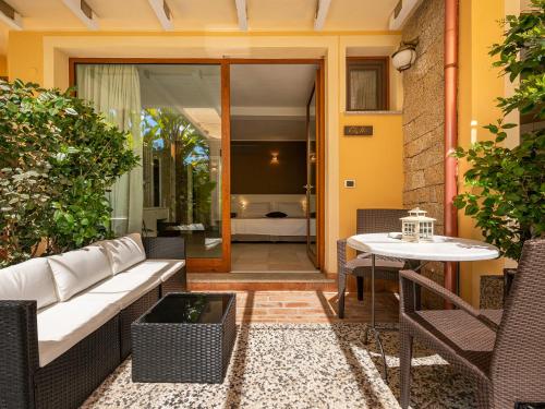 a patio with a white couch and a table at B&B Giglio di Chia in Domus de Maria