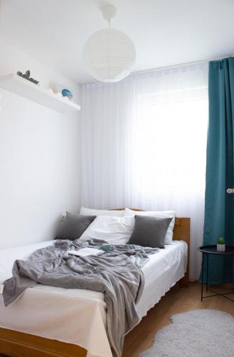 a bedroom with a bed with a blue curtain at Laurel Apartments in Bar