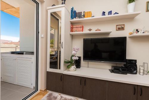 a living room with a flat screen tv on a wall at Chic apartment Zoja near beach with free parking in Makarska