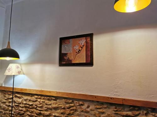 eine Wand mit Bild und Lampe in der Unterkunft Casa Rural l'Avia Tica in Benisuera