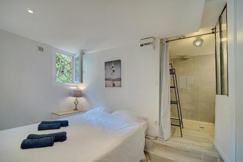 une chambre avec un lit avec deux serviettes bleues dessus dans l'établissement Le Alex - 800m des plages - extérieur - Verrière Côte d'Azur, à Cannes