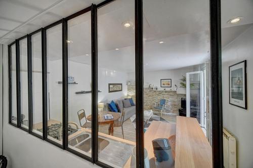 Il comprend un salon doté de baies vitrées et une salle à manger. dans l'établissement Le Alex - 800m des plages - extérieur - Verrière Côte d'Azur, à Cannes