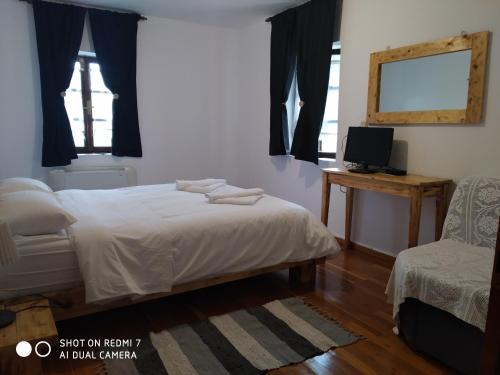 een slaapkamer met een bed, een stoel en een spiegel bij XENONAS SOULIOU in Samonída