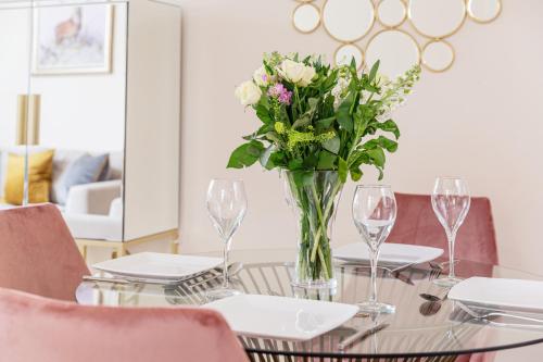 
a table topped with a vase filled with flowers at 10 Saint James - By Luxury Apartments in Cheltenham
