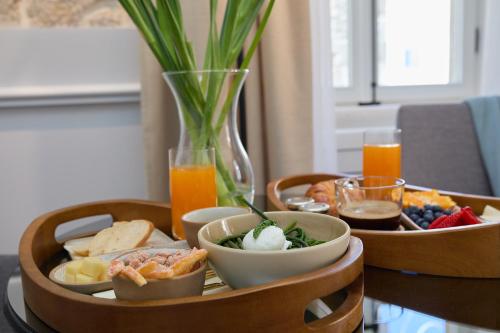a table with two wooden trays of food and drinks at Bota Palace in Dubrovnik