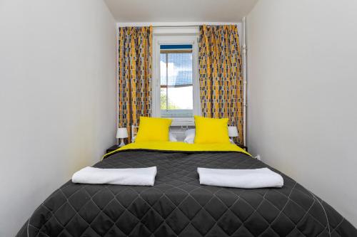 - une chambre avec un lit doté d'oreillers jaunes et d'une fenêtre dans l'établissement ShortStayPoland Dickensa (B31), à Varsovie