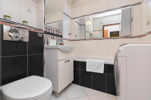 La salle de bains est pourvue de toilettes, d'un lavabo et d'un miroir. dans l'établissement ShortStayPoland Dickensa (B31), à Varsovie