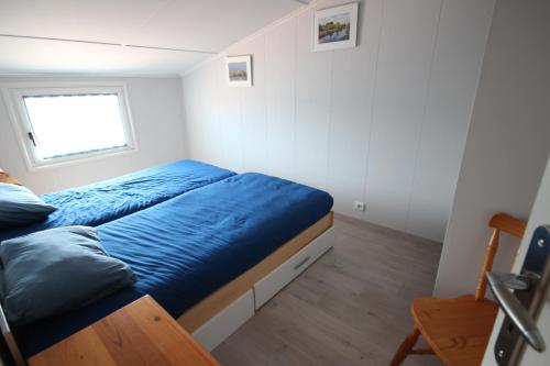 - une chambre avec un lit doté de draps bleus et une fenêtre dans l'établissement Belle maison climatisée dans le domaine PORTES DU SOLEIL, 3 chambres, Wifi, animations et piscines en supplément PORTIRAGNES PLAGE LRPDSA17, à Portiragnes