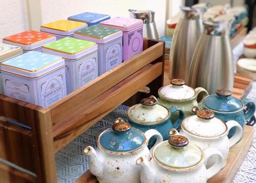 a group of teapots on a wooden shelf at Pestana Collection Plaza Mayor in Madrid