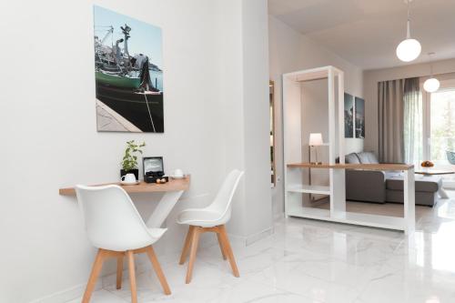 a room with a desk and chairs and a bedroom at Blue View Apartments in Kavala