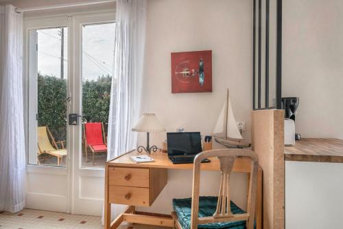 un bureau avec un bureau et un ordinateur dans l'établissement Maison avec jardin à 140m de la Plage, à Saint-Michel-Chef-Chef
