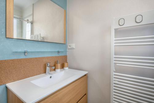a bathroom with a white sink and a mirror at Maison avec jardin à 140m de la Plage in Saint-Michel-Chef-Chef
